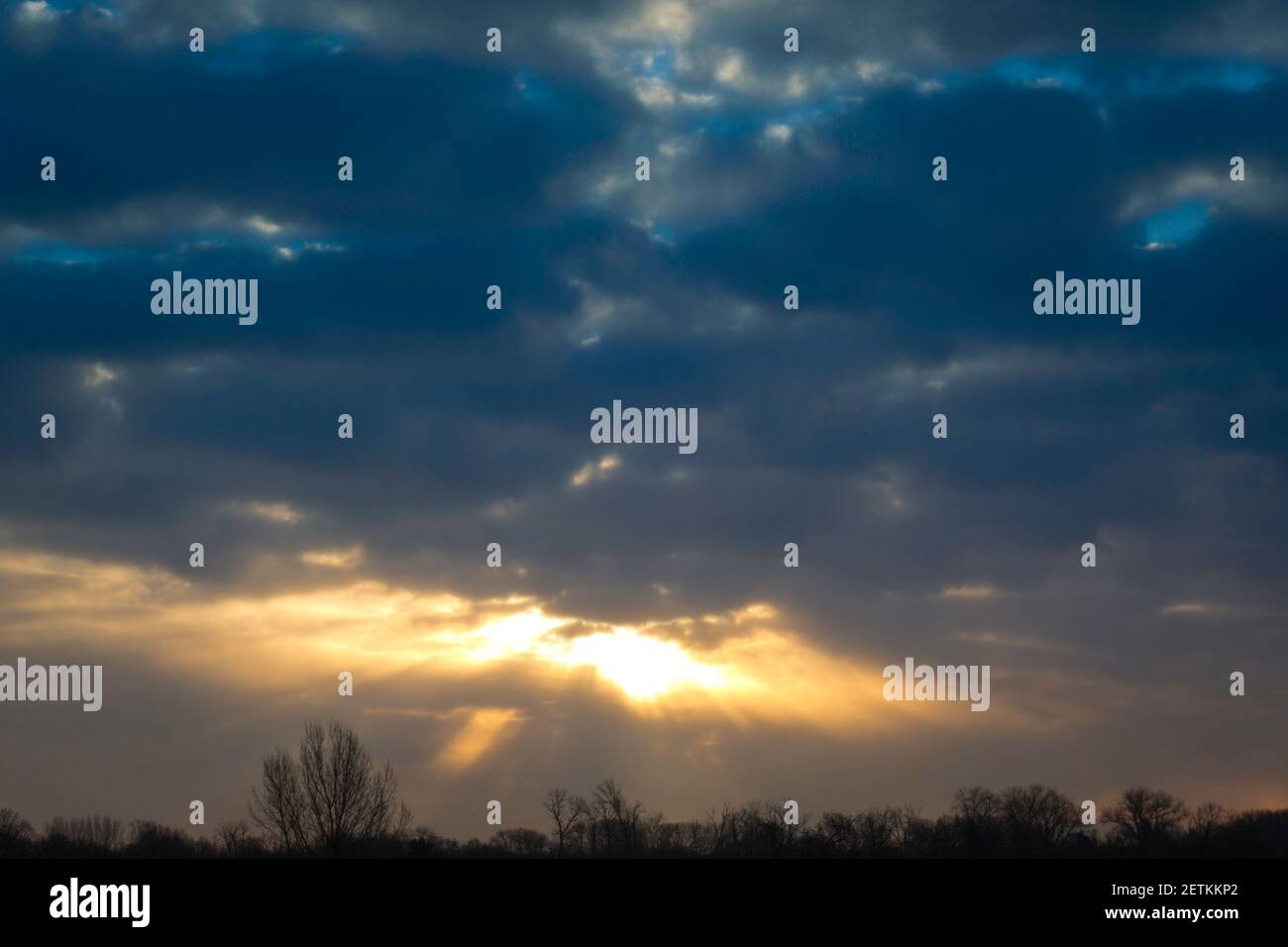 cielo celeste mistico con raggi di sole che escono da dietro nuvole Foto Stock
