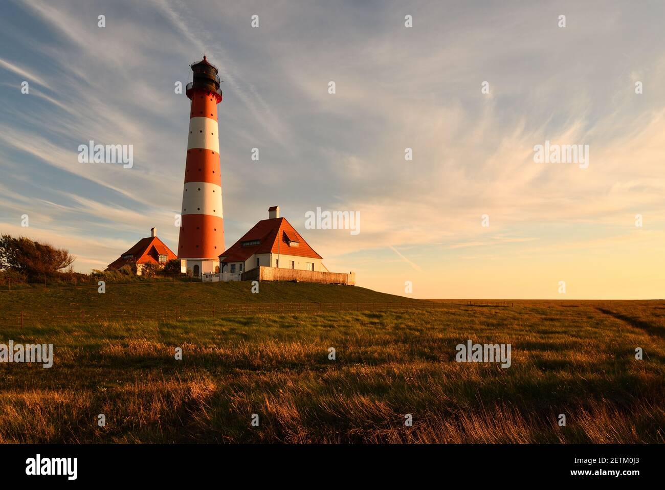Un maestoso paesaggio torbido sullo storico faro di Westerheversand a Schleswig-Holstein, Germania Foto Stock