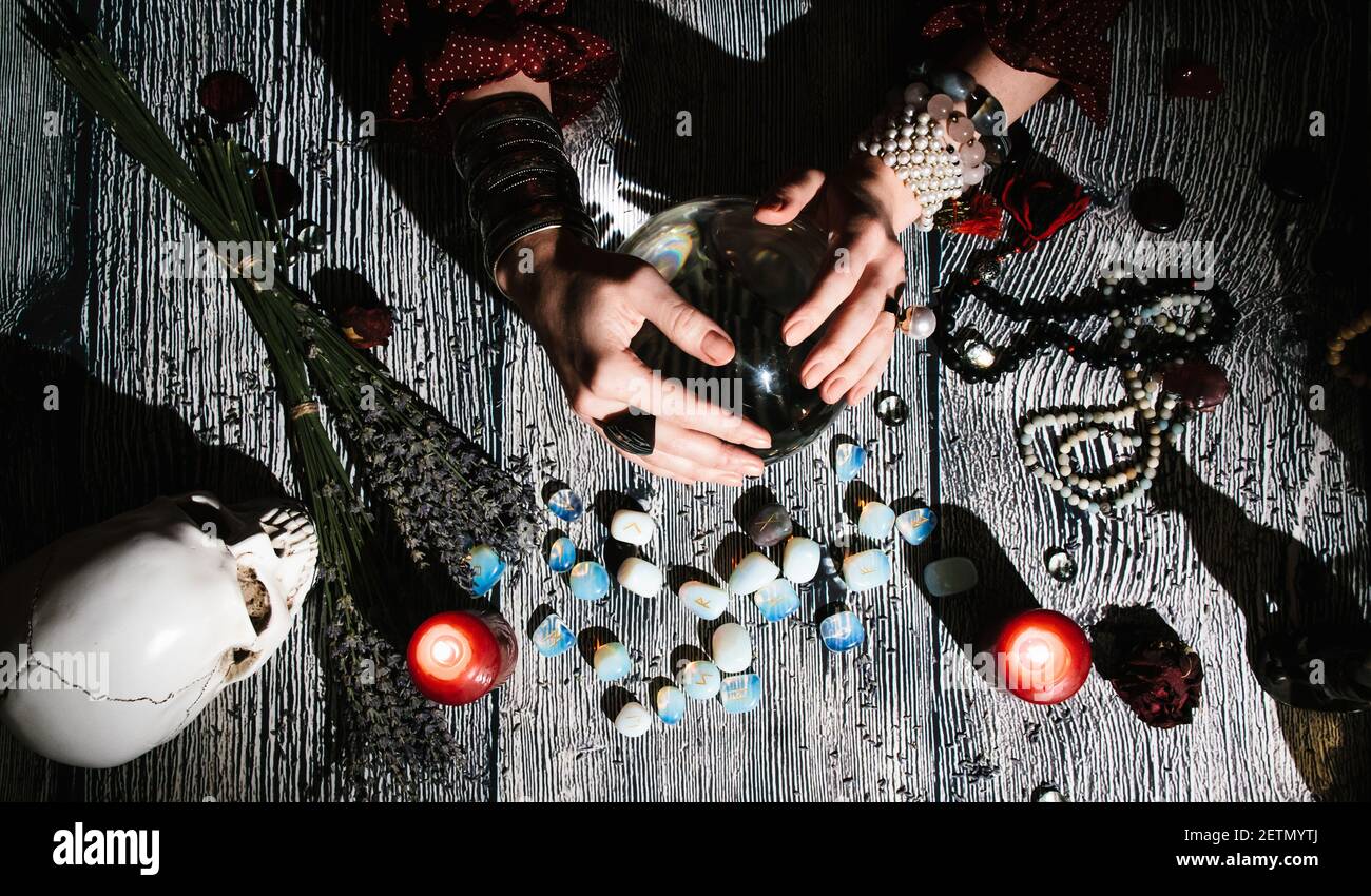 Mani di fortuneteller con rune di pietra, vista dall'alto. Previsione del futuro. Interno Mystic. Foto Stock