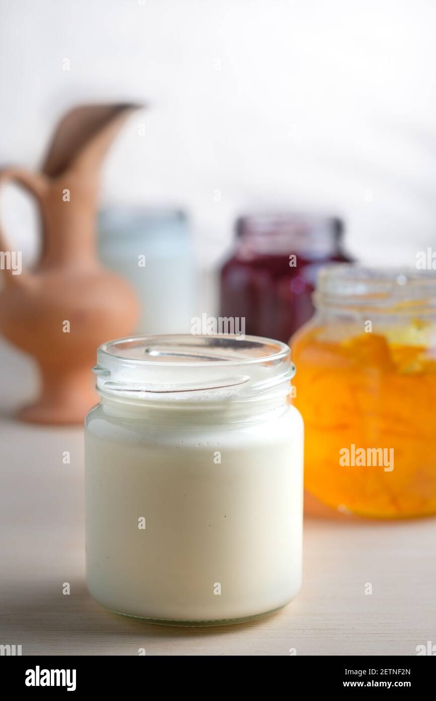 Yogurt fatto in casa con cucchiaio di marmellata d'arancia da mangiare da un vaso di vetro. Sana colazione probiotica casearia. Foto Stock