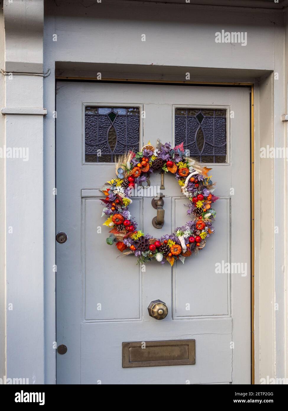 Colorata corona di Natale su una porta di casa nella città mercato di Olney, Buckinghamshire, Regno Unito Foto Stock