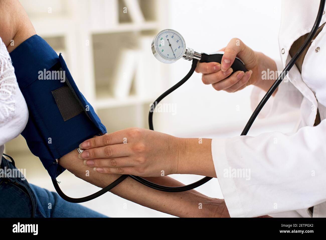 Medico femminile che controlla la pressione sanguigna della donna anziana  in ambulanza Foto stock - Alamy