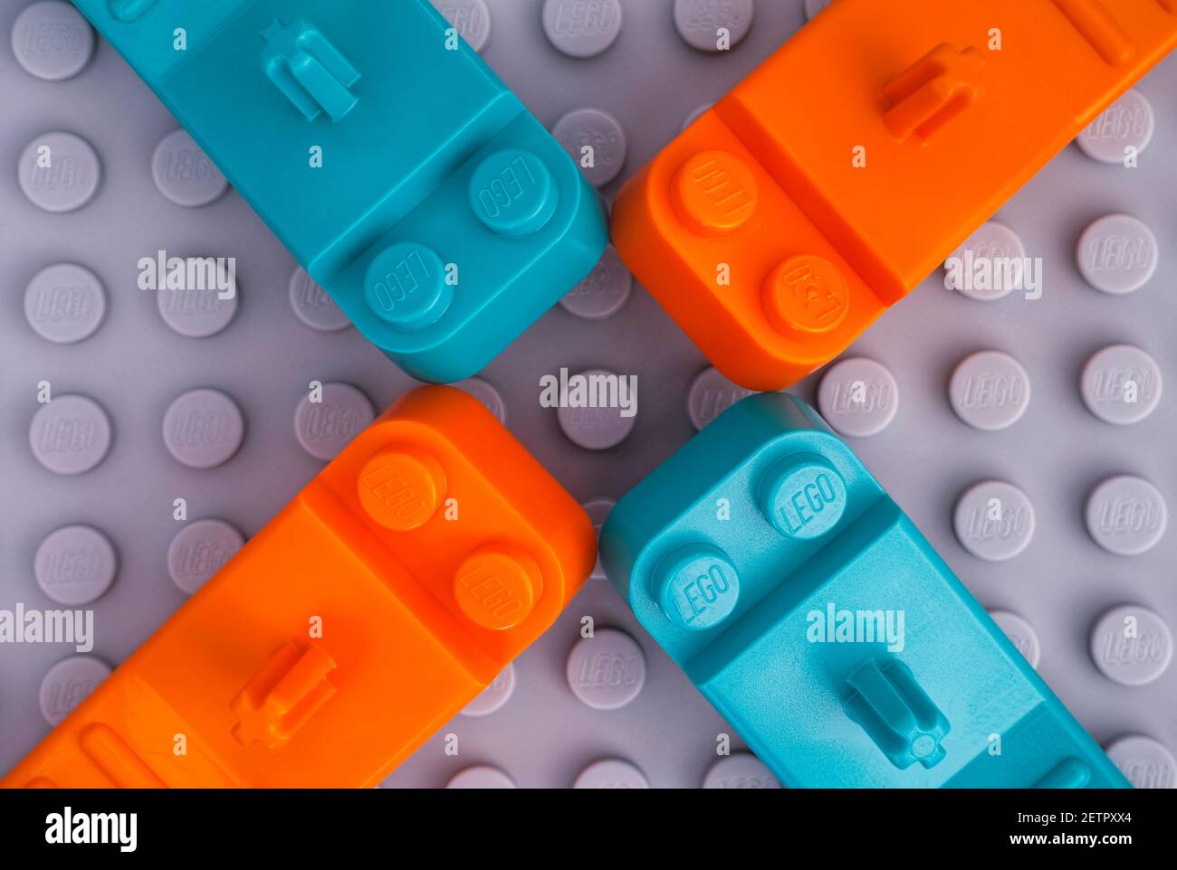 Tambov, Federazione Russa - 17 gennaio 2021 quattro lego teal e arancio Brick separatori su sfondo grigio piastra base. Foto Stock