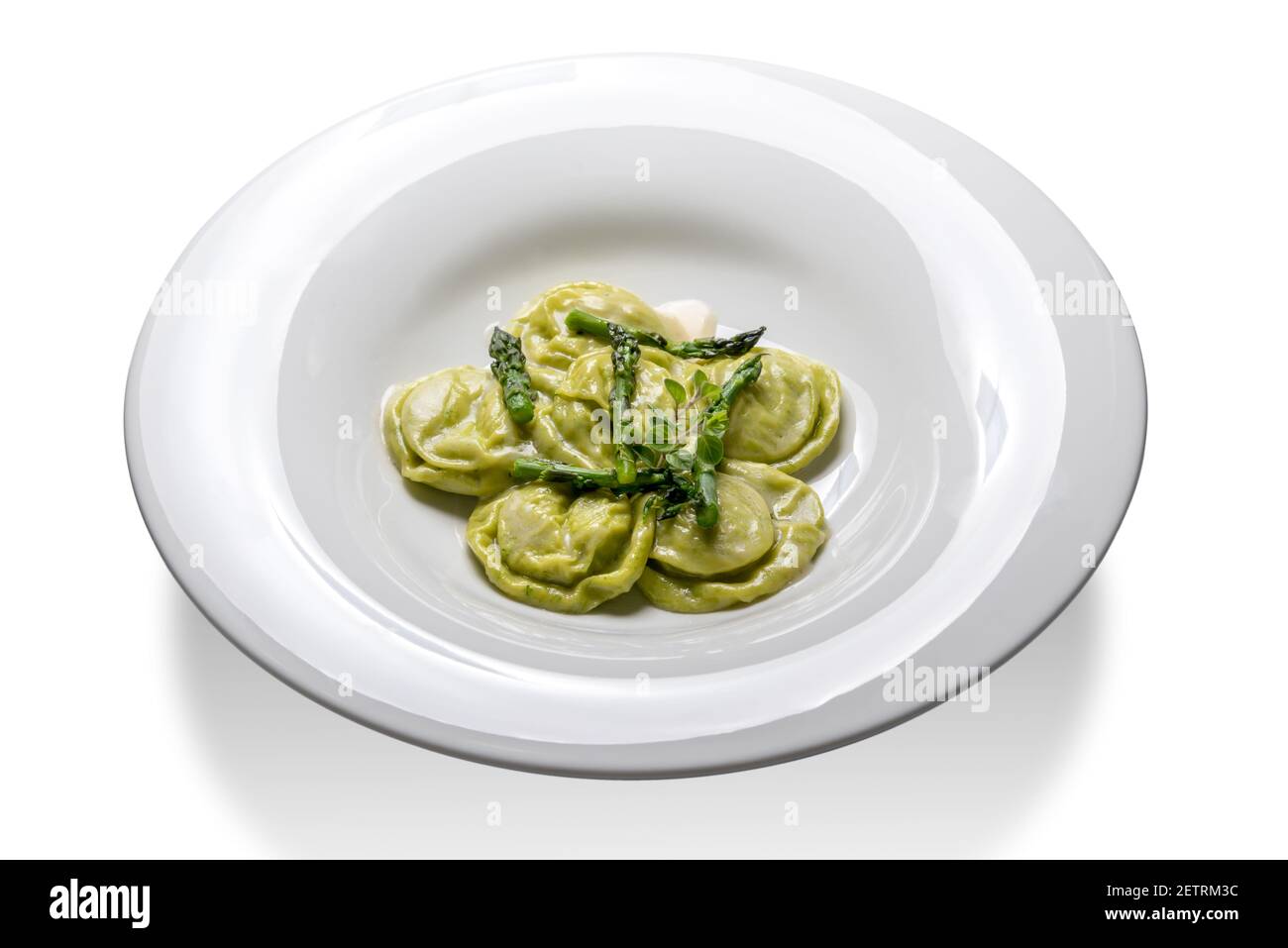 Tortelli verdi con asparagi e maggiorana. Ravioli di pasta verde in piastra isolata su bianco Foto Stock