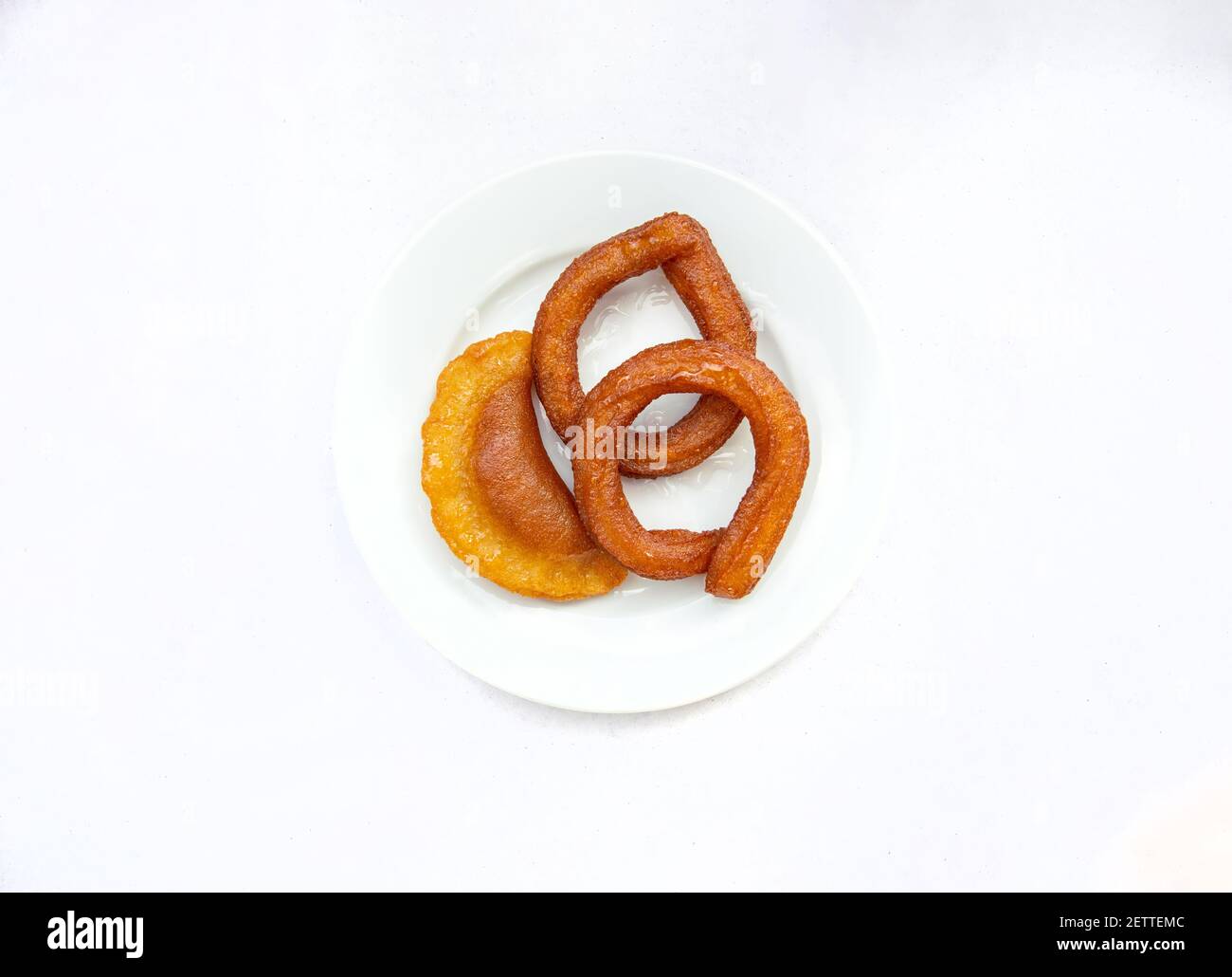 Tradizionale dolce anello turco Halka Tatli. Dessert fritti circolari. Dolci arabi Ramadan Kareem su tavolo di legno. Turco o arabo des Foto Stock