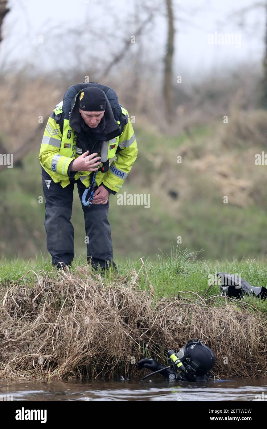 Un ufficiale del Garda parla con un subacqueo a Ardreigh Lock fuori Athy, Co Kildare, dove la ricerca è ripresa per un uomo che è andato perso la domenica durante il salvataggio di un bambino in un incidente di kayak. Un allarme è stato sollevato dopo che l'uomo e il bambino sono stati in difficoltà dopo un kayak rovesciato sul fiume Barrow. Data immagine: Martedì 2 marzo 2021. Foto Stock