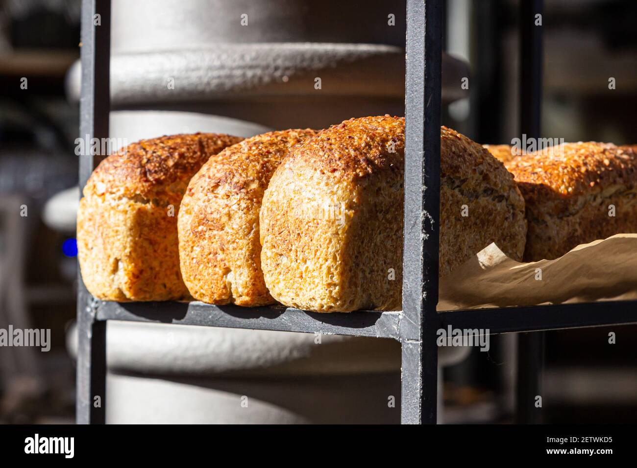 Pane artigianale appena sfornato su un ripiano in una panetteria. Pane gourmet in vendita. Messa a fuoco selettiva. Foto Stock
