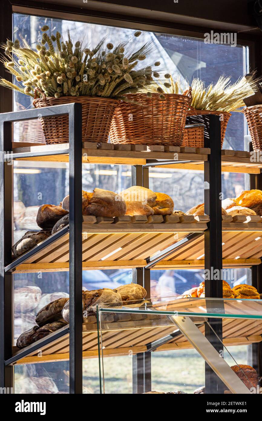 Varietà di pane artigianale appena sfornato su un ripiano in un negozio di panetteria. Pane gourmet in vendita. Messa a fuoco selettiva. Foto Stock