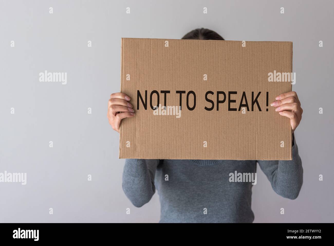 Una donna ha una bandiera con l'iscrizione DI NON PARLARE davanti a lei. Foto Stock