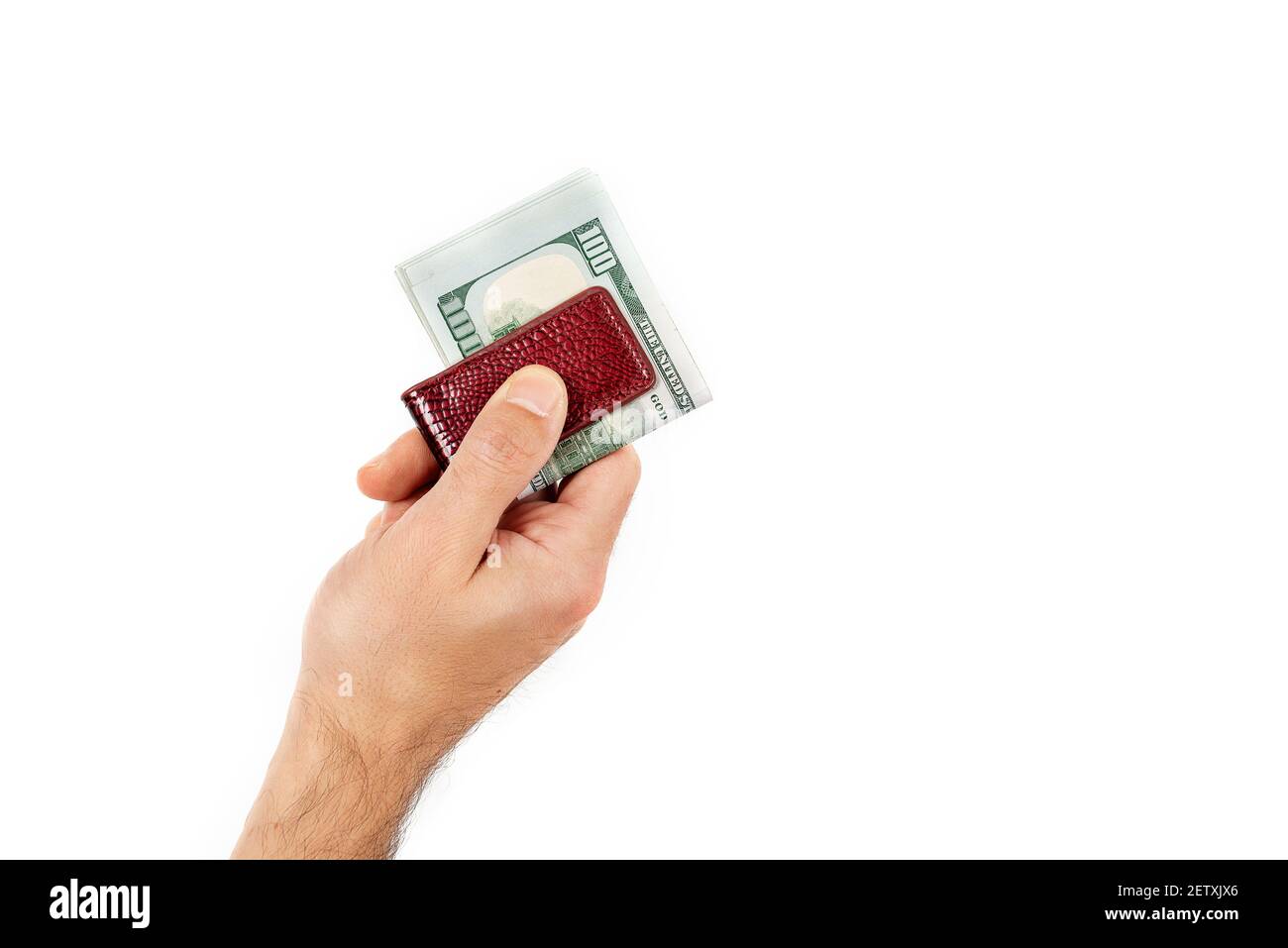 Primo piano della mano del maschio tiene fuori i dollari clampati con una clip di soldi isolata su uno sfondo bianco. Valuta del dollaro USA Foto Stock