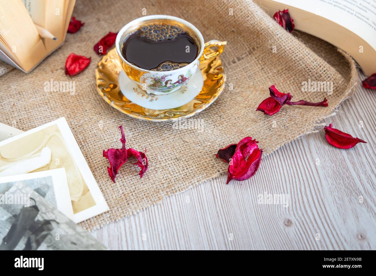 Turkısh caffè in tazza classica, sfondo in legno con petali romantici di rosa, libro sull'amore tra le vecchie immagini d'annata, decorare con colore beige, Foto Stock