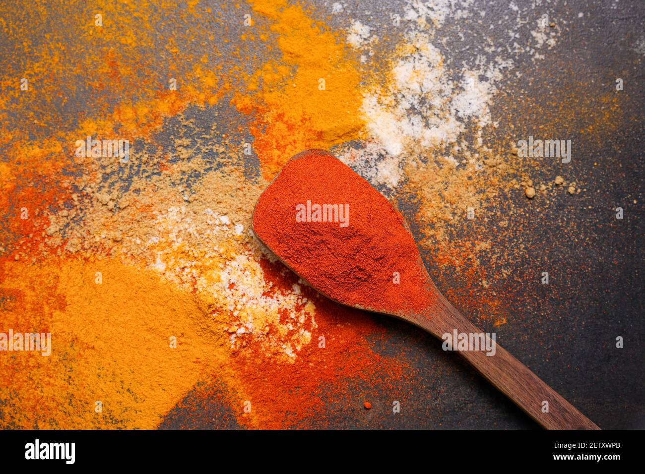 Donna indiana polvere mano spezie indiane rosso freddo, peperoncino paprika polvere esplosione splash utilizzando mortaio di pietra cucina indiana Kerala India Sri Lanka Foto Stock