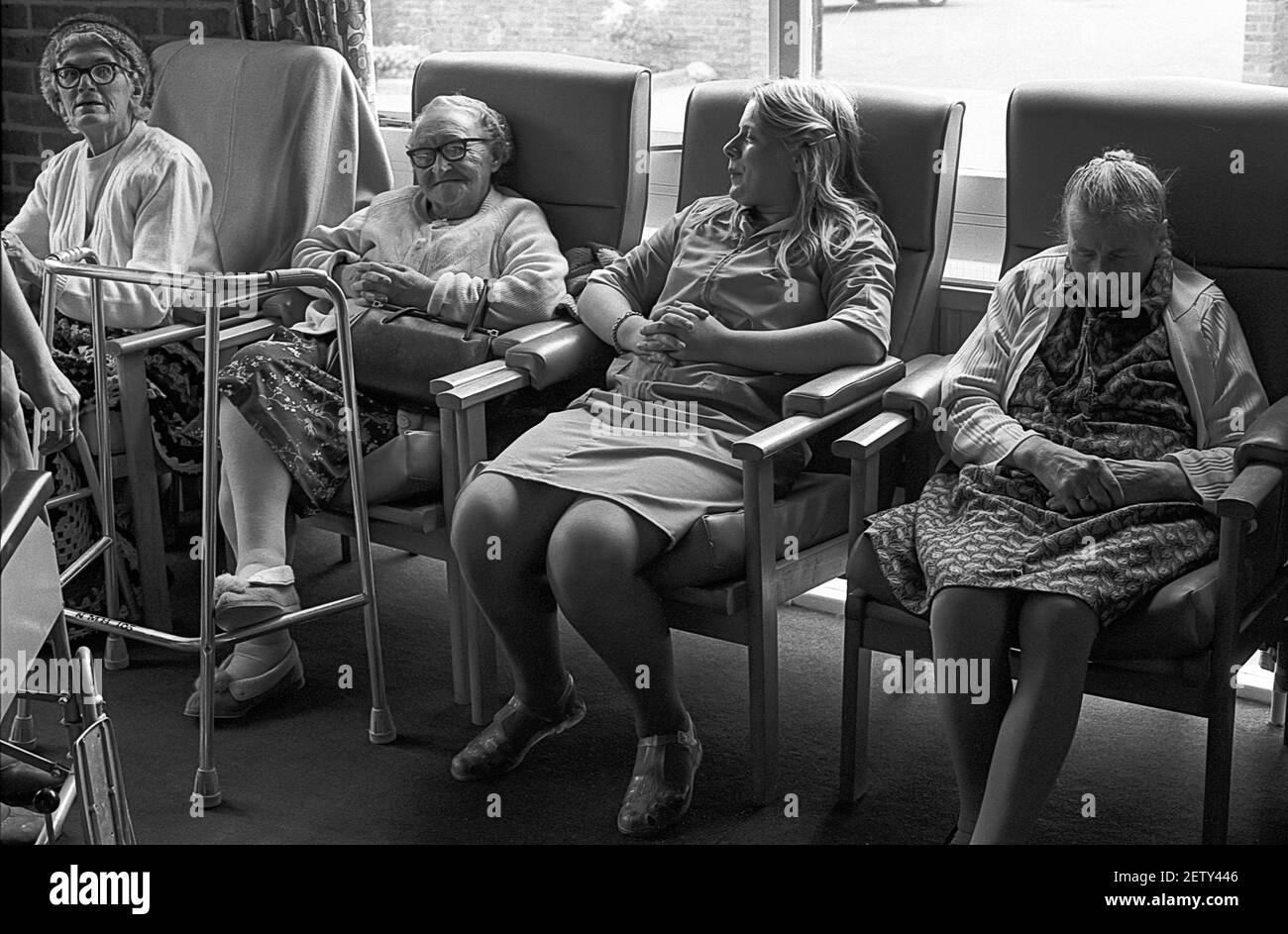 Sedici anni ragazza di scuola sul lavoro esperienza come assistente di cura in casa di cura. Parlare con un gruppo di donne anziane Foto Stock