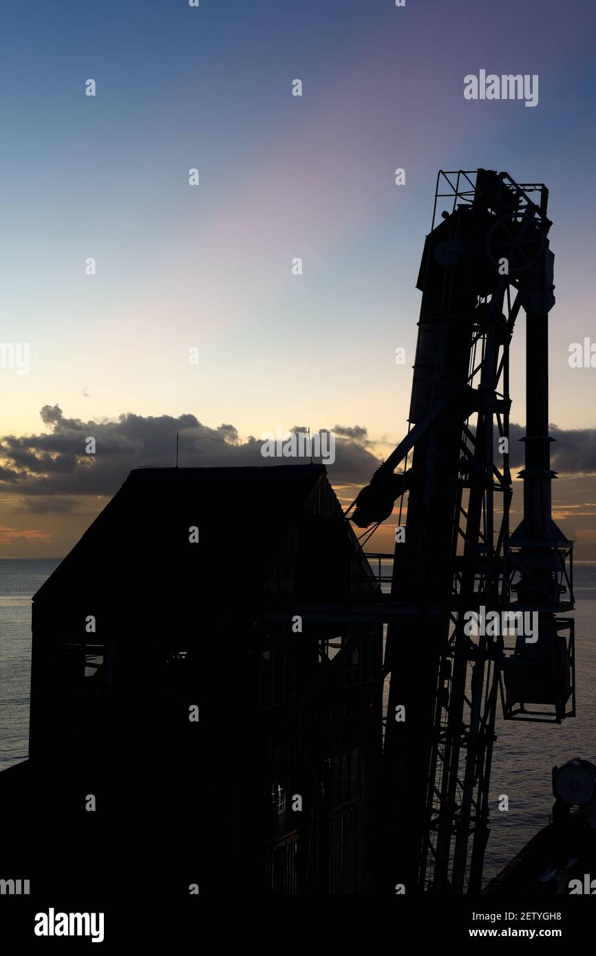 La silhouette inquietante delle attrezzature industriali a lato della banchina a Bridgetown Port Barbados Foto Stock