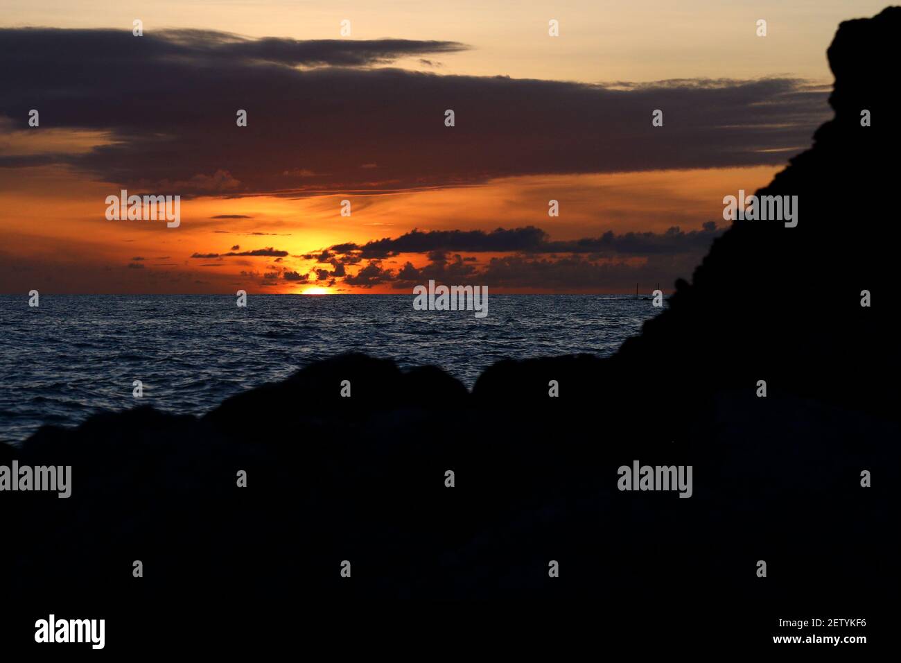 Tramonto costiero tra le rocce di Bridgetown Barbados Foto Stock