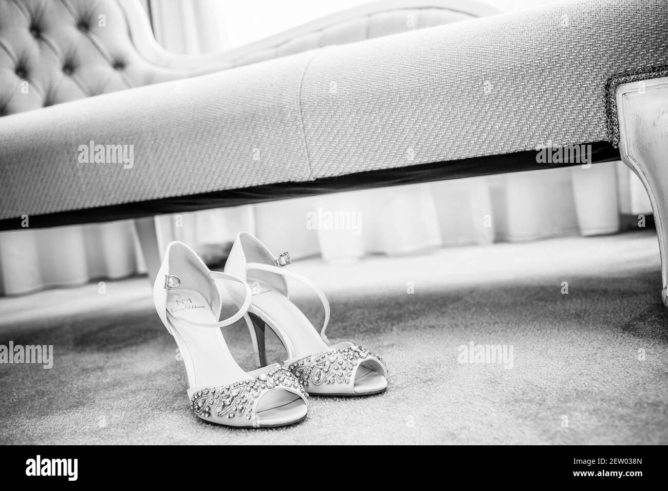 Scarpe da sposa sotto la Chaise Lounge nella suite nuziale Foto Stock