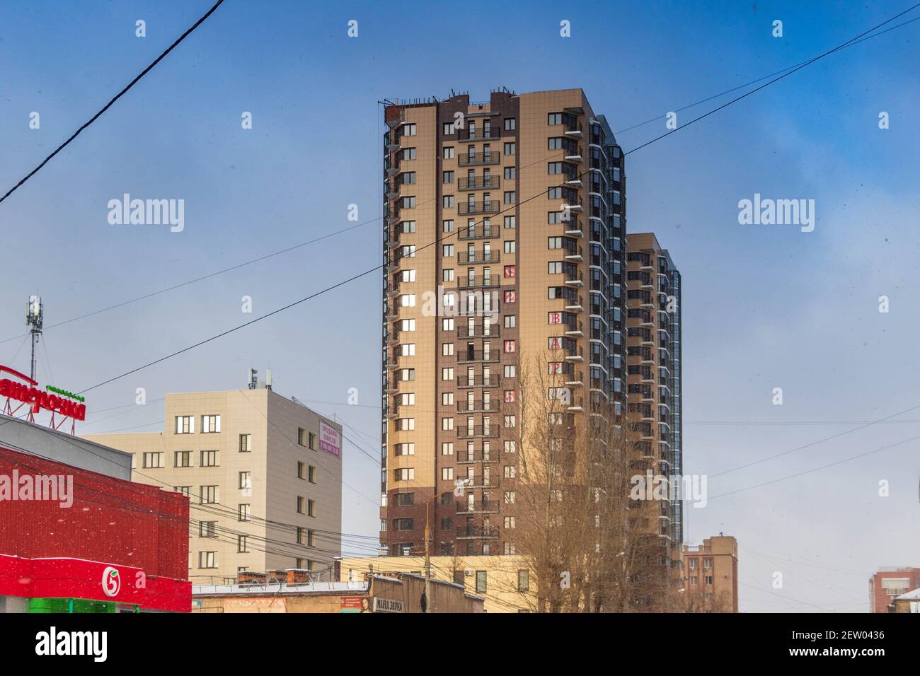 Chelyabinsk, Russia - 14 novembre 2020. Architettura urbana, edificio residenziale a più piani, illuminato dalla luce del sole, contro il cielo. Foto Stock