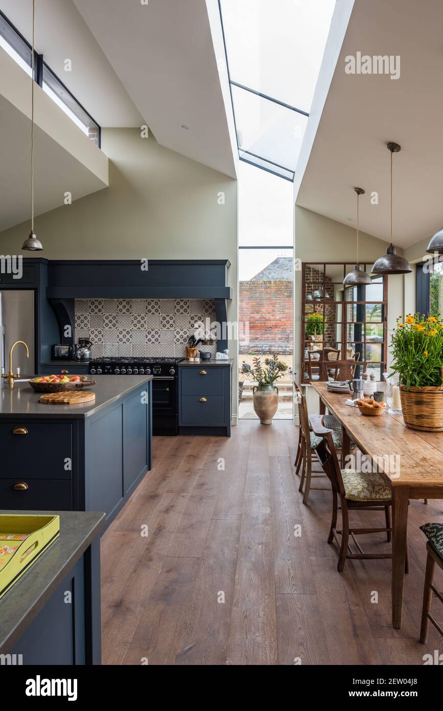 Cucina a pianta aperta a due piani di Tom Dunn in ristrutturazione casale off-grid. Foto Stock