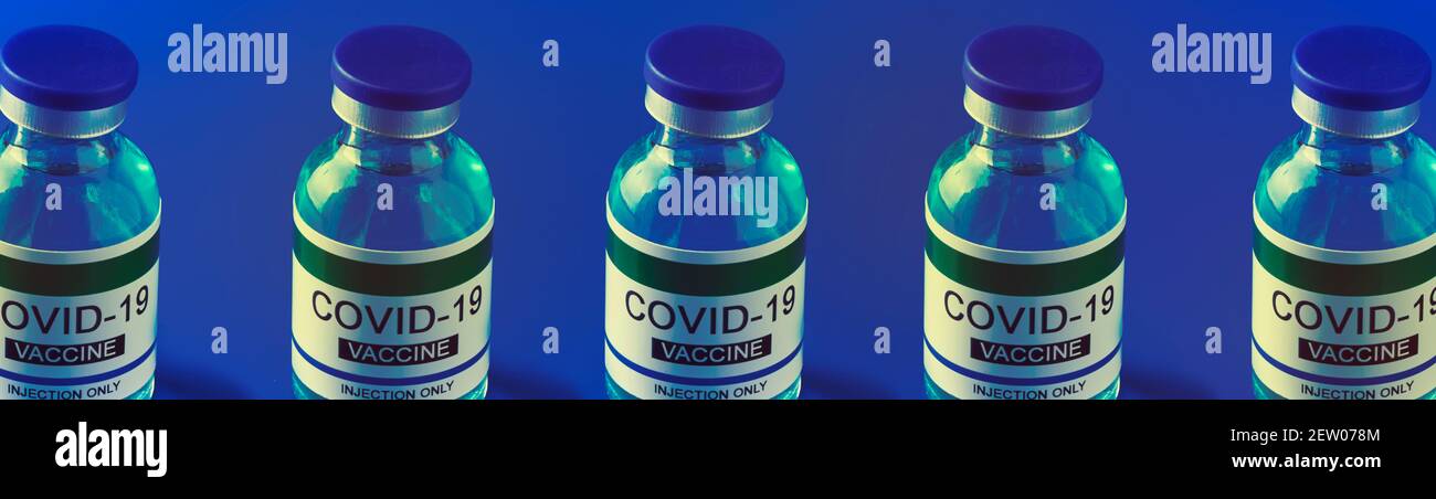 alcune bottiglie simulate di vaccino covid-19 su sfondo blu, in formato panoramico da utilizzare come banner o intestazione web Foto Stock