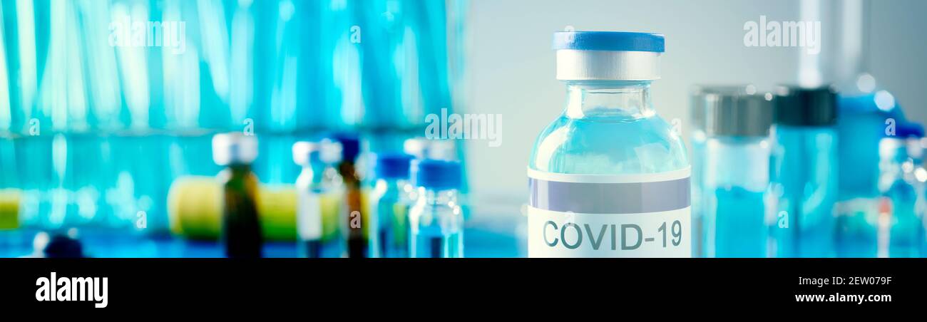closeup di una bottiglia vaccinale simulata di covid-19 su un tavolo, in laboratorio, in un formato panoramico da utilizzare come banner web o intestazione Foto Stock