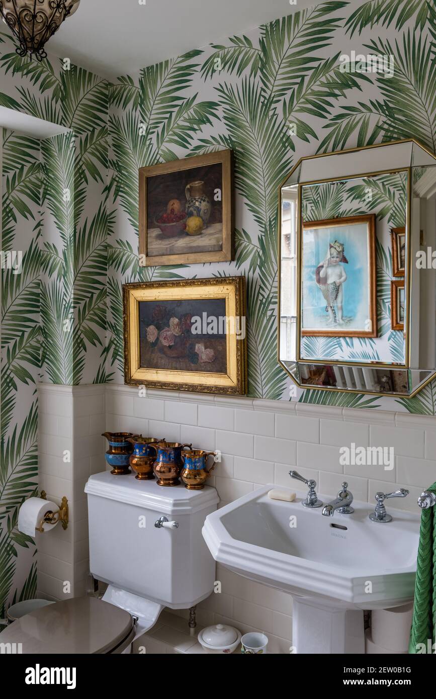 Carta da parati Palm Leaf con armadietto a specchio sopra il lavello in  piastrelle Bagno Dorset Foto stock - Alamy