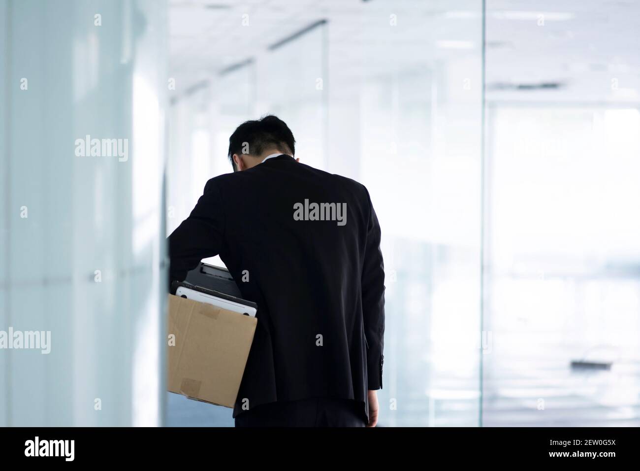 Infornato uomo d'affari che lascia l'ufficio con la scatola di appartiene Foto Stock