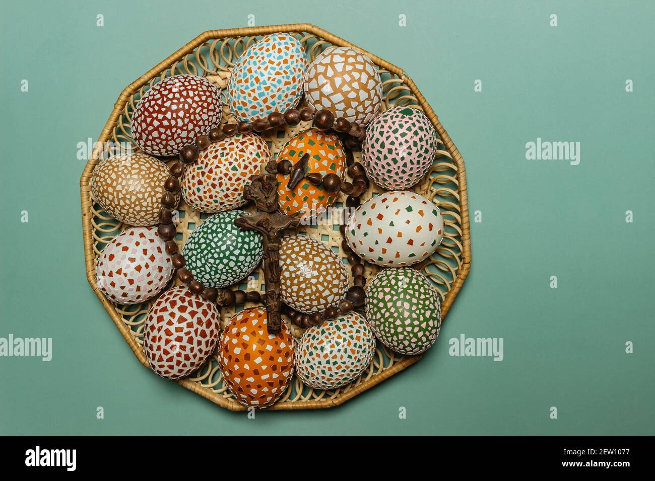 Happy Easter.colorful fatto a mano uova di Pasqua con crocifisso in legno cesto copia spazio per text.Spring decorazione sfondo. Tradizione festosa Foto Stock