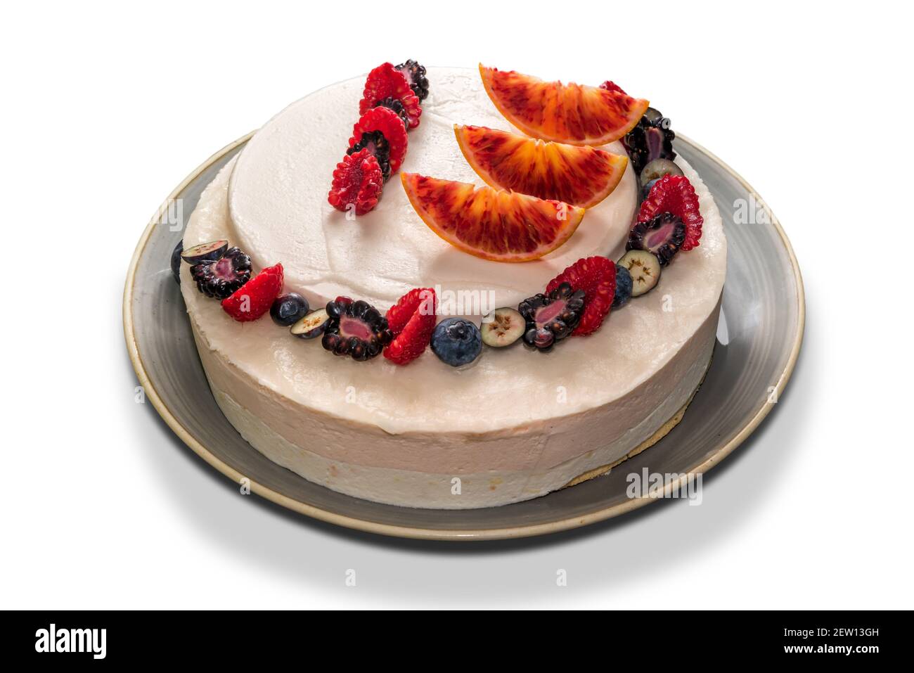 cheesecake con fette di arancia e lamponi e mirtillo, torta intera isolata su bianco Foto Stock