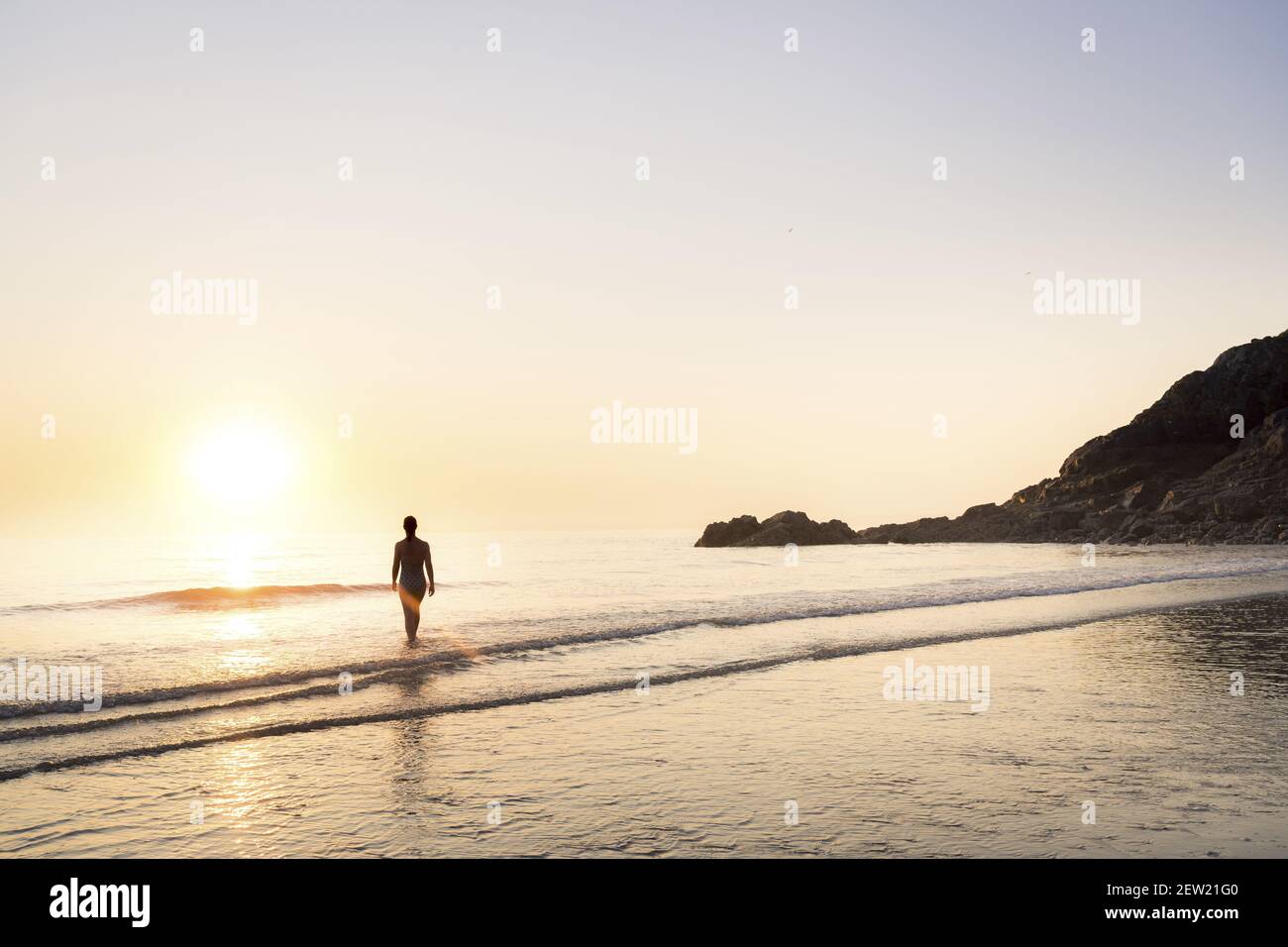 Francia, Cotes d'Armor, Plérin, giovane donna che bagna all'alba a Martin plage Foto Stock