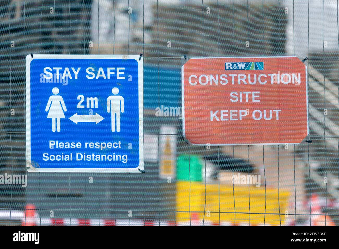 Regno Unito 2 metro Covid social distanziing segno & tenere fuori segno su rete recinto di un sito di progetto di ingegneria civile. Per l'industria edile del Regno Unito durante Covid Foto Stock