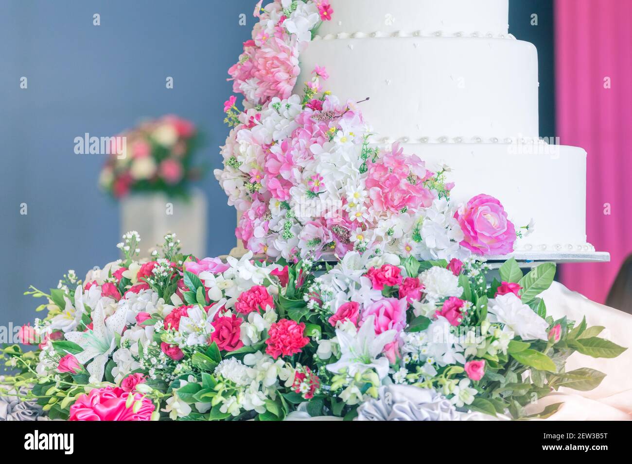 Torta di nozze bianca con fiori in un giorno felice della coppia Foto Stock