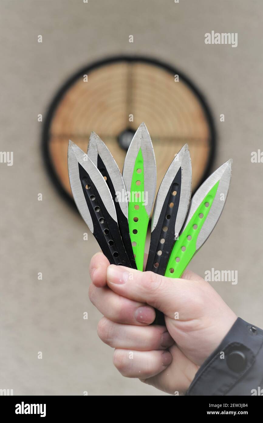 Lancio di coltelli. Sport e hobby . Lancio di coltelli primo piano e un bersaglio sulla parete.Sport all'aperto. Concetto di raggiungimento degli obiettivi. Foto Stock