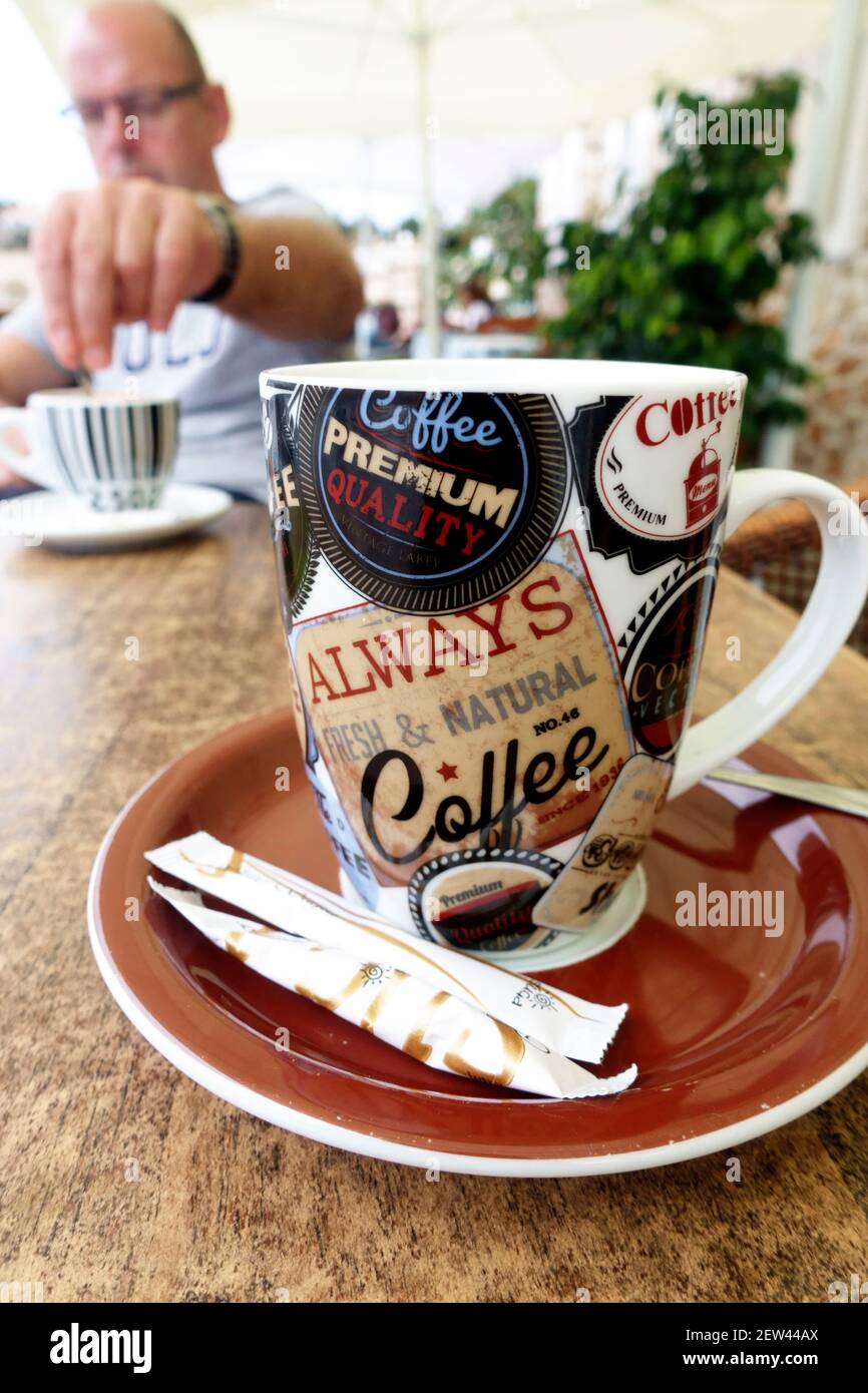 Tazza di caffè e piattino con zucchero sul lato dentro un caffè Foto Stock