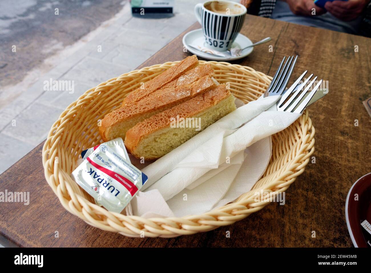 Cestino di pane, burro e posate, tipicamente servito nei ristoranti greci prima dell'arrivo del pasto Foto Stock