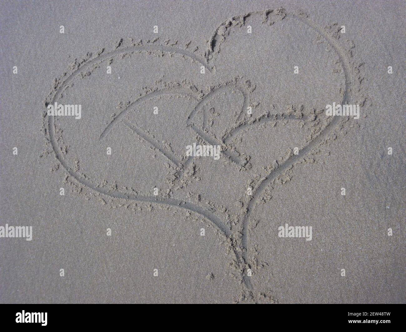 Una vista dall'alto del cuore che si disegna sulla sabbia Con lettere D e R. Foto Stock