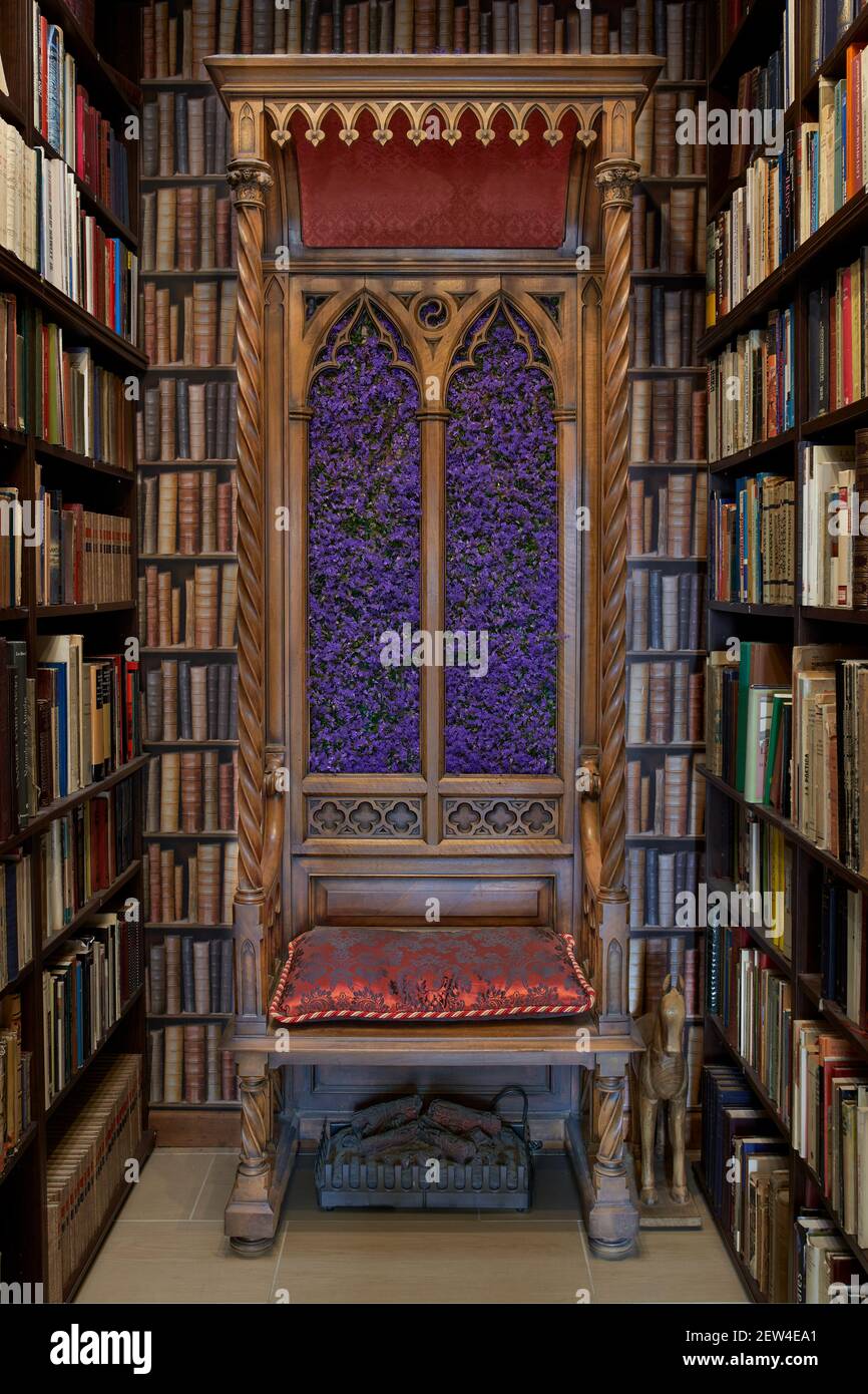 Trono di legno con cuscino rosso in una libreria piena di libri Foto stock  - Alamy