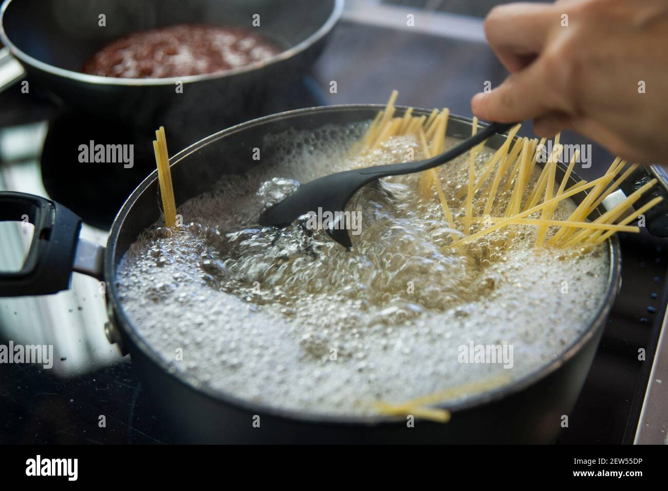 Cucinare gli spaghetti in una pentola con acqua bollente Foto Stock