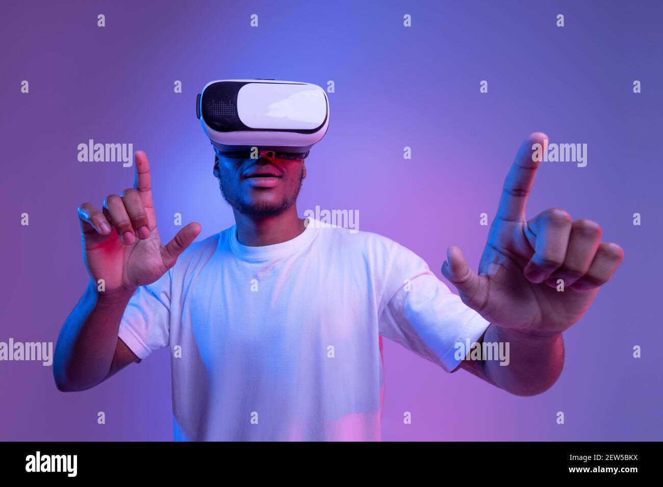 Tecnologie di gioco. Eccitati gli afroamericani Guy in occhiali VR sotto Néon Lighting Foto Stock