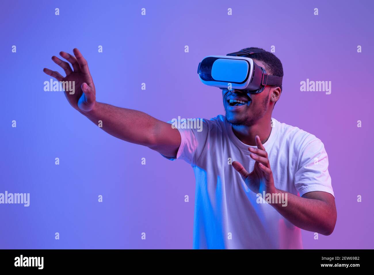 Stupito Black Man in VR Headset vivere la realtà virtuale, giocare a videogiochi Foto Stock