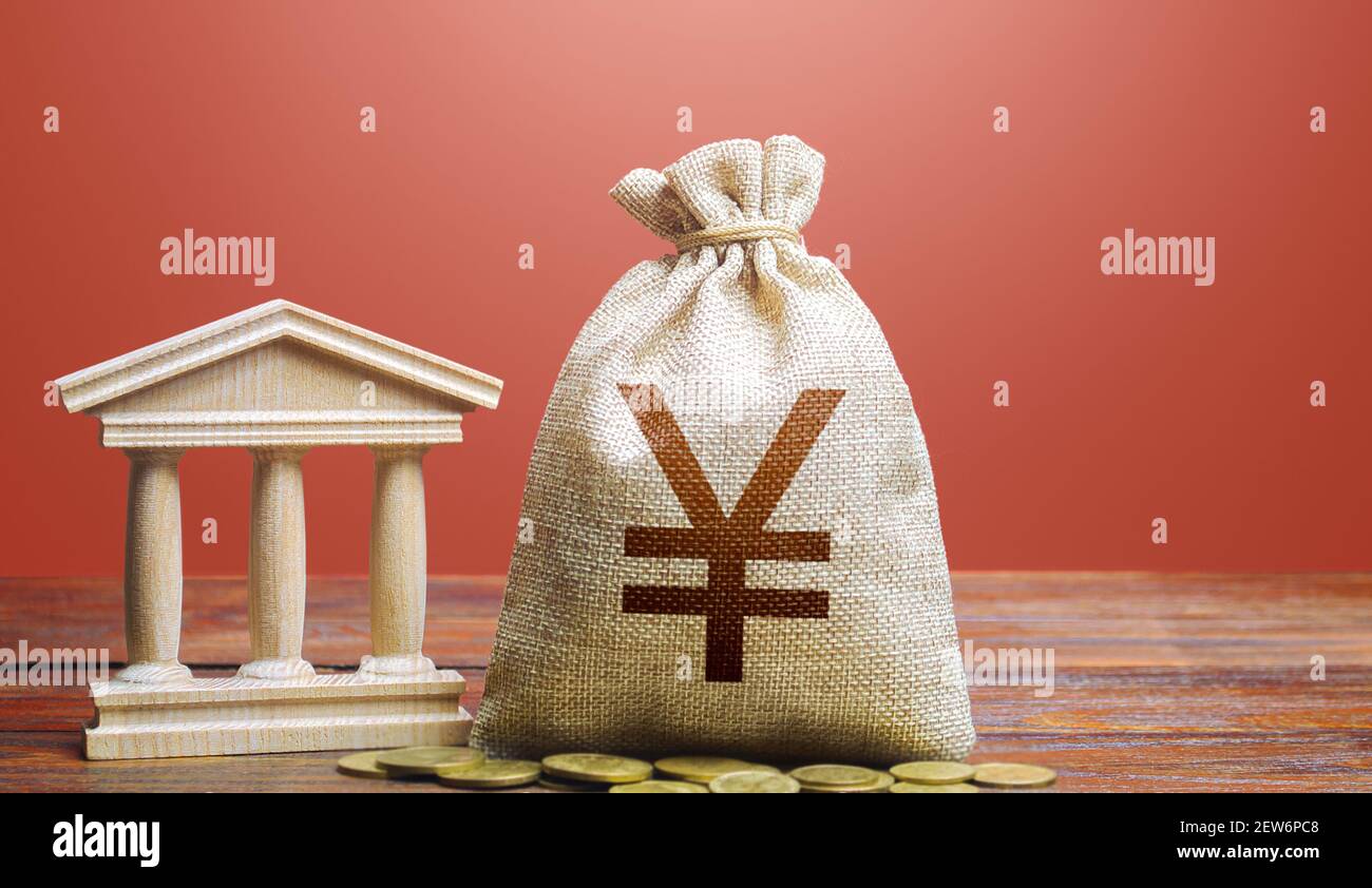 Borsa di denaro Yuan o Yen e edificio bancario/governativo. Politica monetaria. Riscossione delle imposte e budget. PIL e PNL. Sostenere le imprese in tempi di crisi Foto Stock