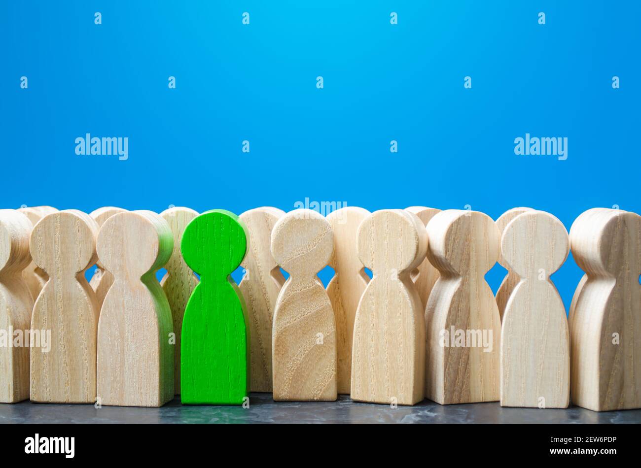 Uomo verde figurine in una folla di persone. Reclutamento di nuovi lavoratori, headhunters. Cerca specialisti di lavoratori di talento. Si distingue dalla folla. Diverso, Foto Stock