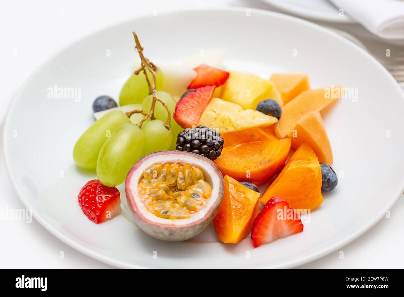 Piatto di frutta fresca a fette per colazione. Su una piastra bianca, passionfruit, Foto Stock