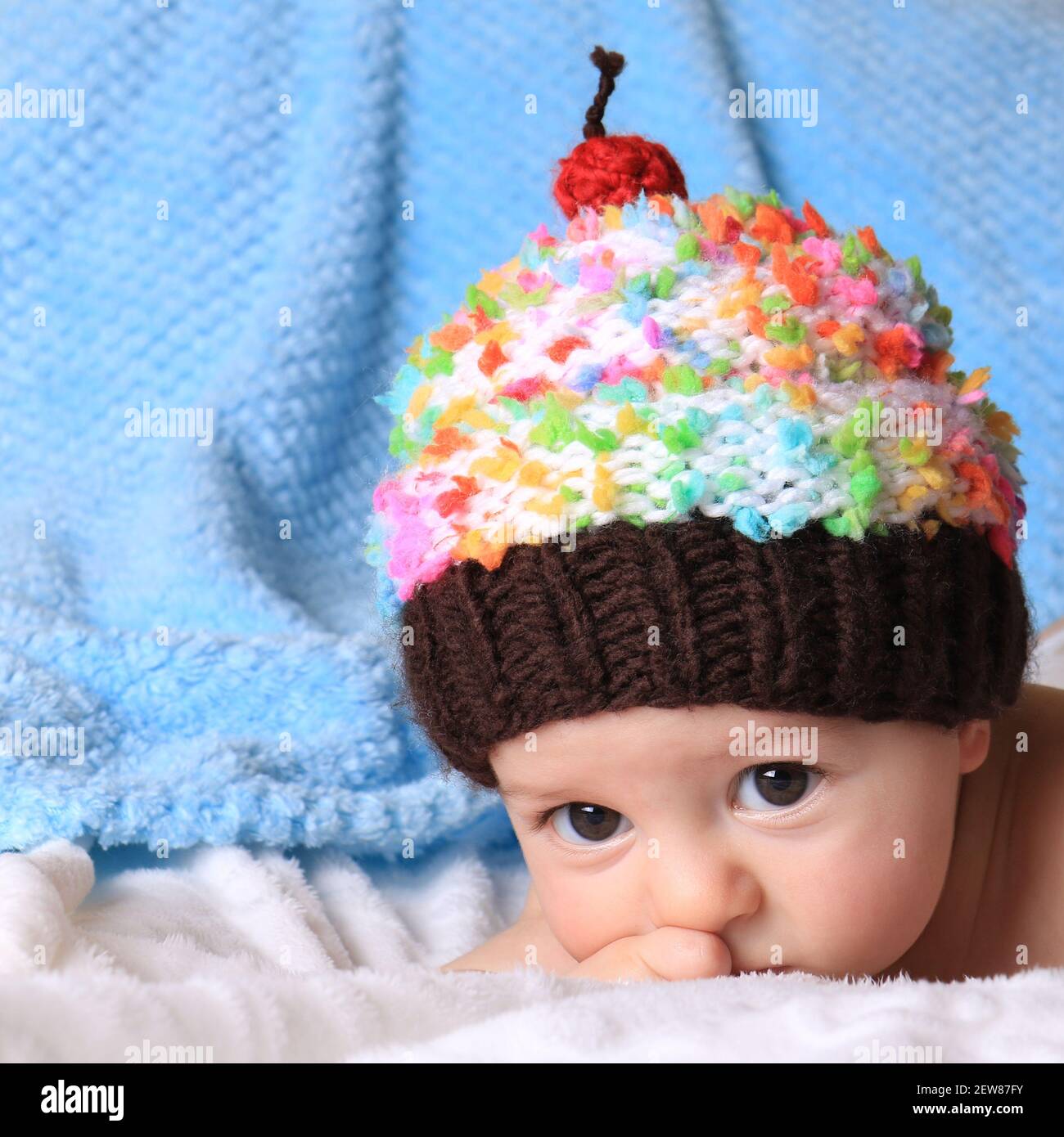 Un adorabile bambino che indossa un cappello da cupcake. Foto Stock