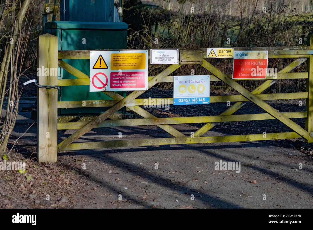 Cancello in legno coperto da cartelli di avvertimento e tenere fuori i cartelli Bloccare l'ingresso alla terra privata nella campagna del Norfolk Foto Stock