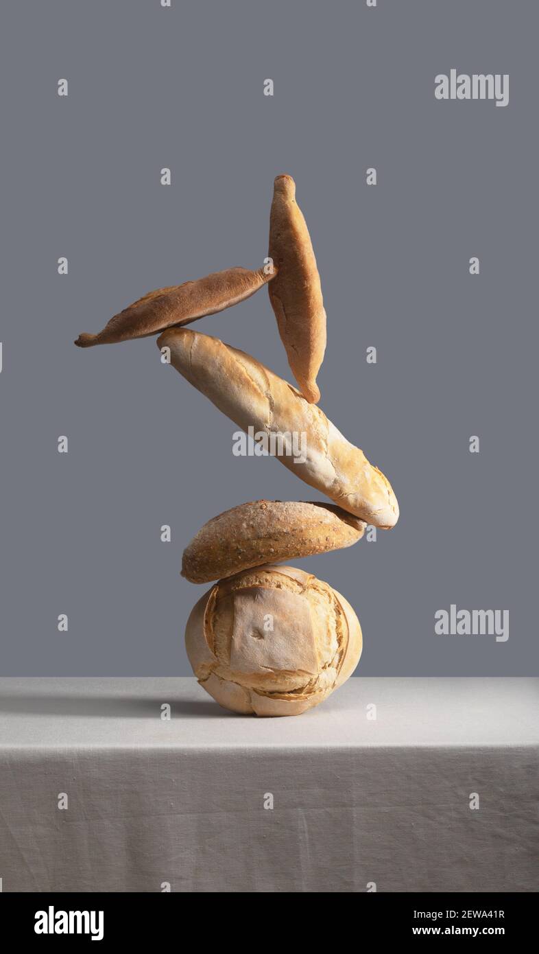 Equilibrare il pane su un tavolo coperto da una tovaglia Foto Stock