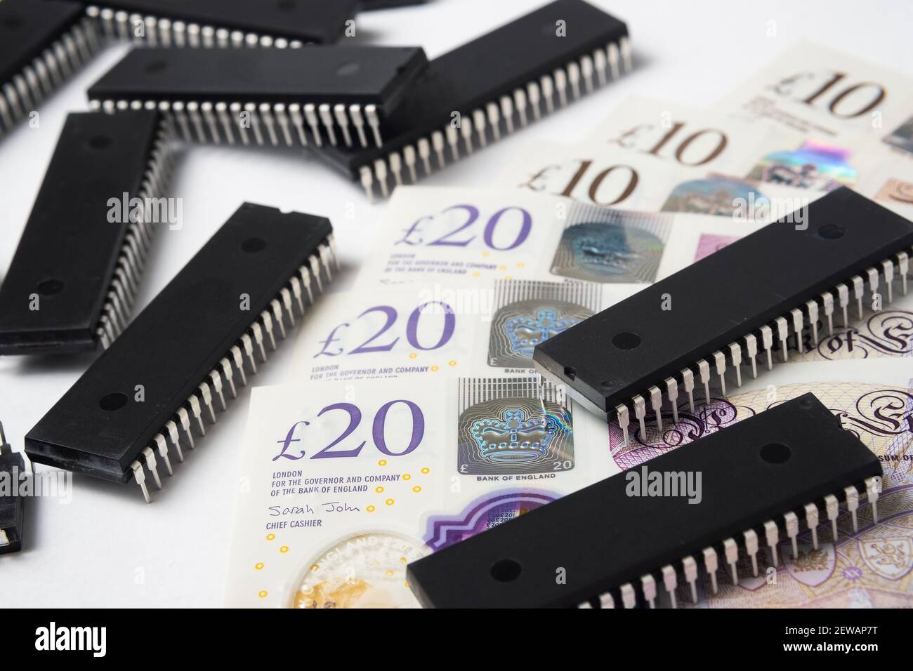 Carenza di chip semiconduttori e prezzo elevato. Pile di chip per computer e diffusione di banconote in sterline britanniche. Concetto di crisi nel settore. Foto Stock