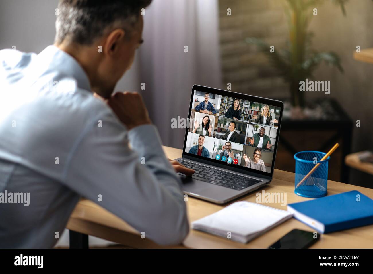 Comunicazione video online. Un uomo d'affari adulto di successo usa un laptop per videoconferenza con i soci d'affari. Un manager o un ceo è seduto alla sua scrivania e sta parlando in videochiamata con i colleghi Foto Stock