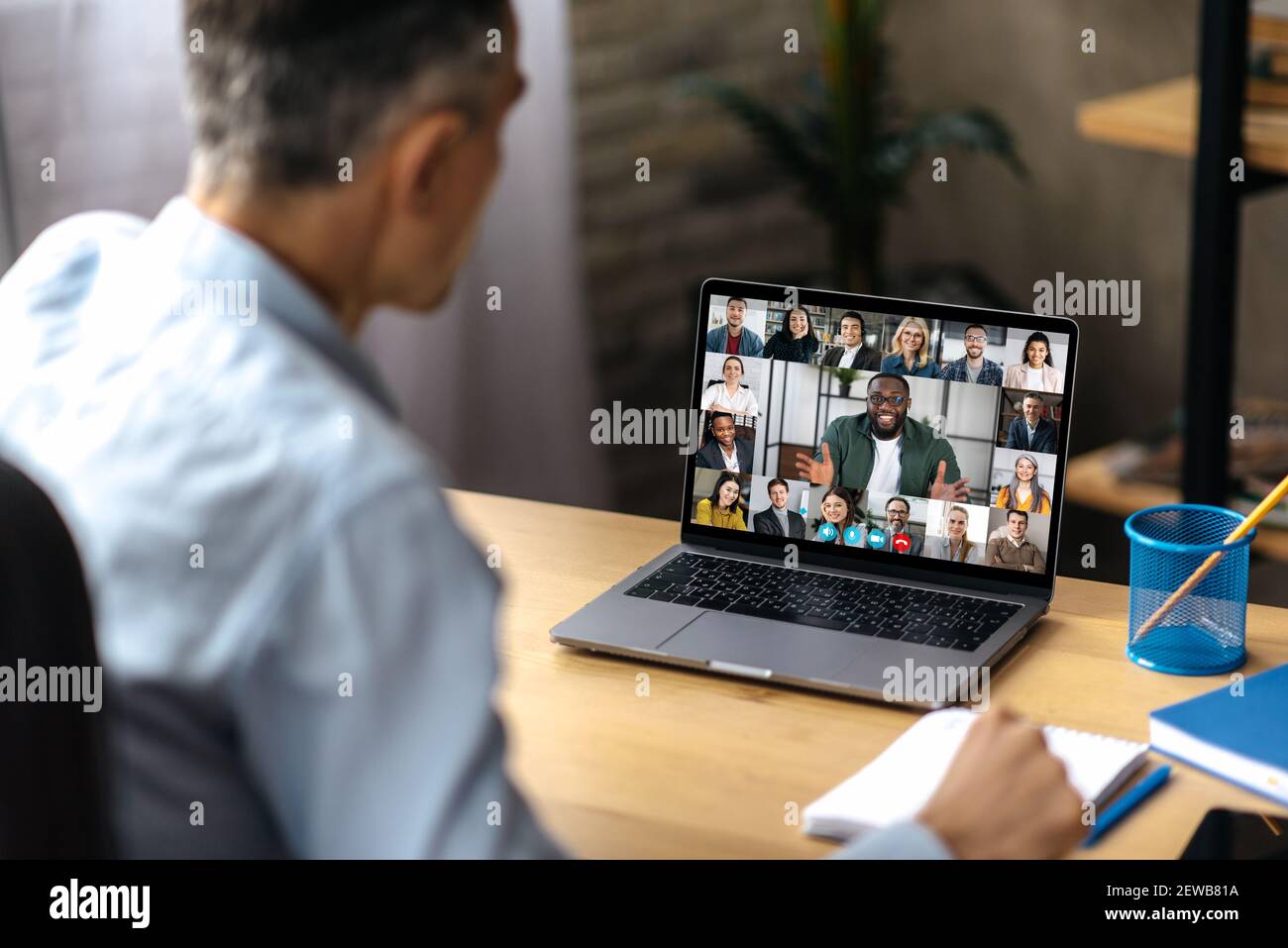 Comunicazione video online. Un uomo d'affari adulto di successo usa un laptop per videoconferenza con i soci d'affari. Un manager o un ceo è seduto alla sua scrivania e sta parlando in videochiamata con i colleghi Foto Stock