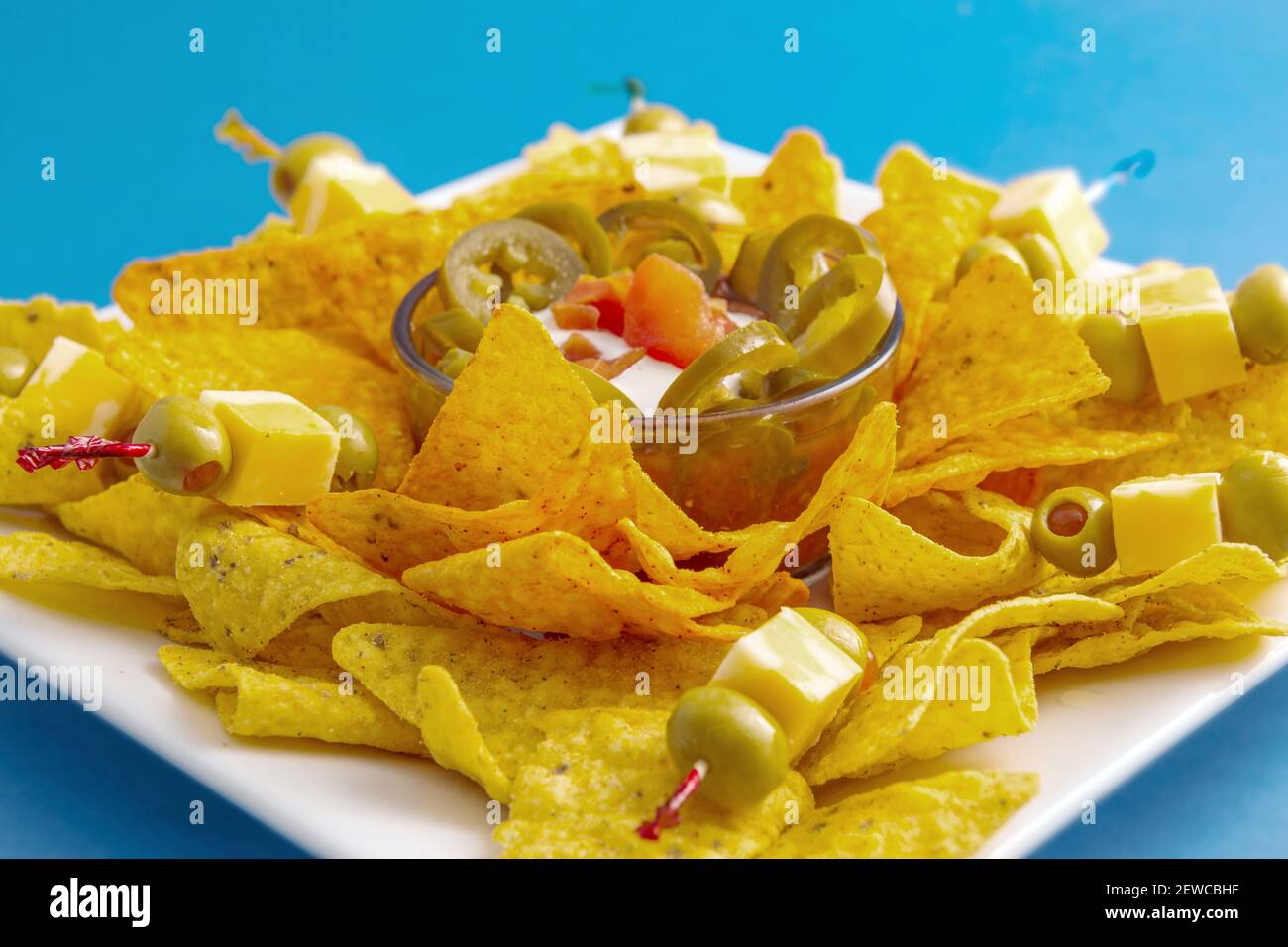 Vassoio di nacho chips con jalapenos e salsa da immersione Foto Stock