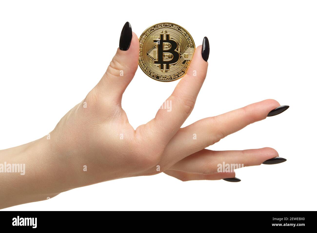 Mano femminile con unghie nere manicure e moneta d'oro in dita. Isolato su sfondo bianco. Concetto di criptovaluta digitale. Foto Stock